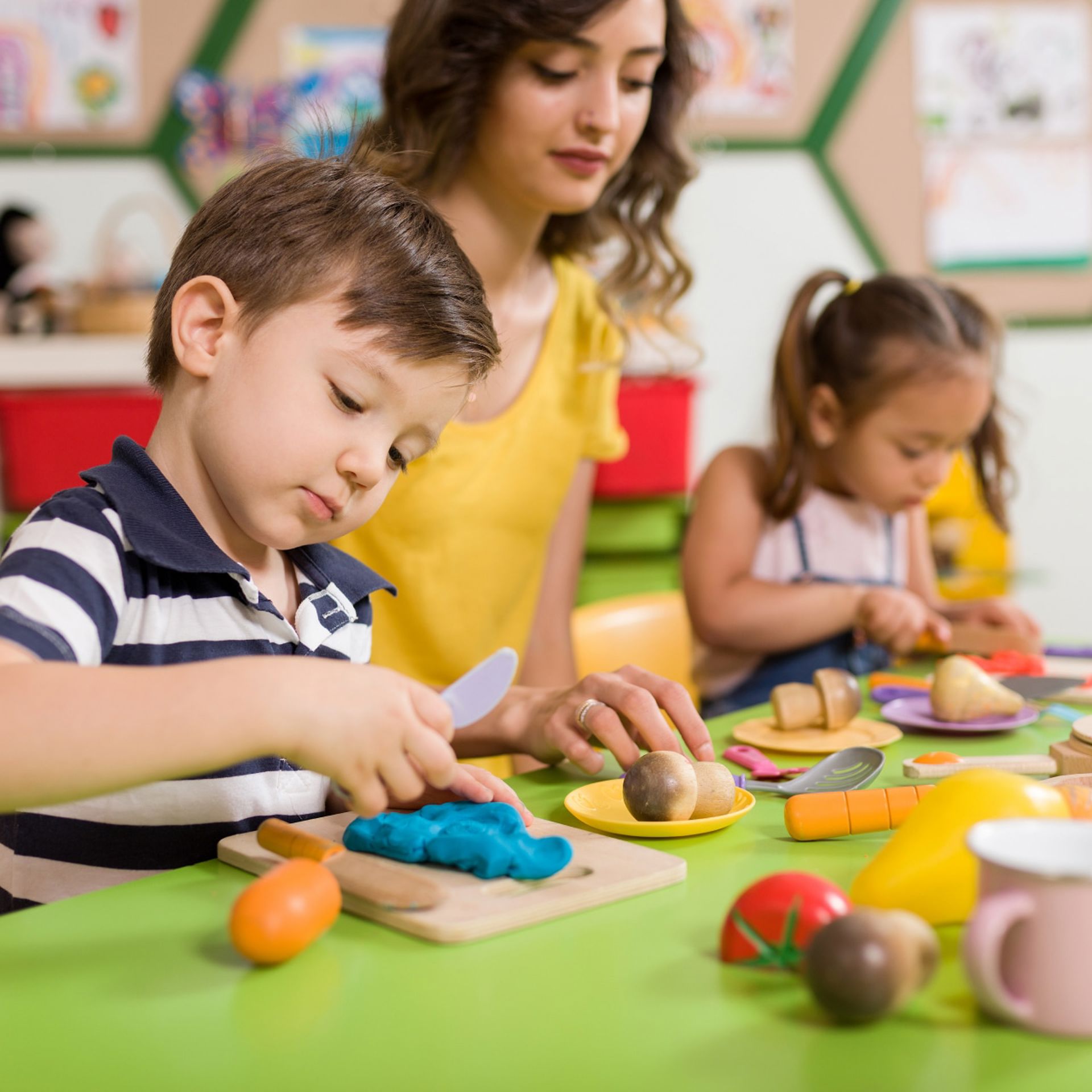 Jeune garçons joue avec des jouets de cuisine en classe