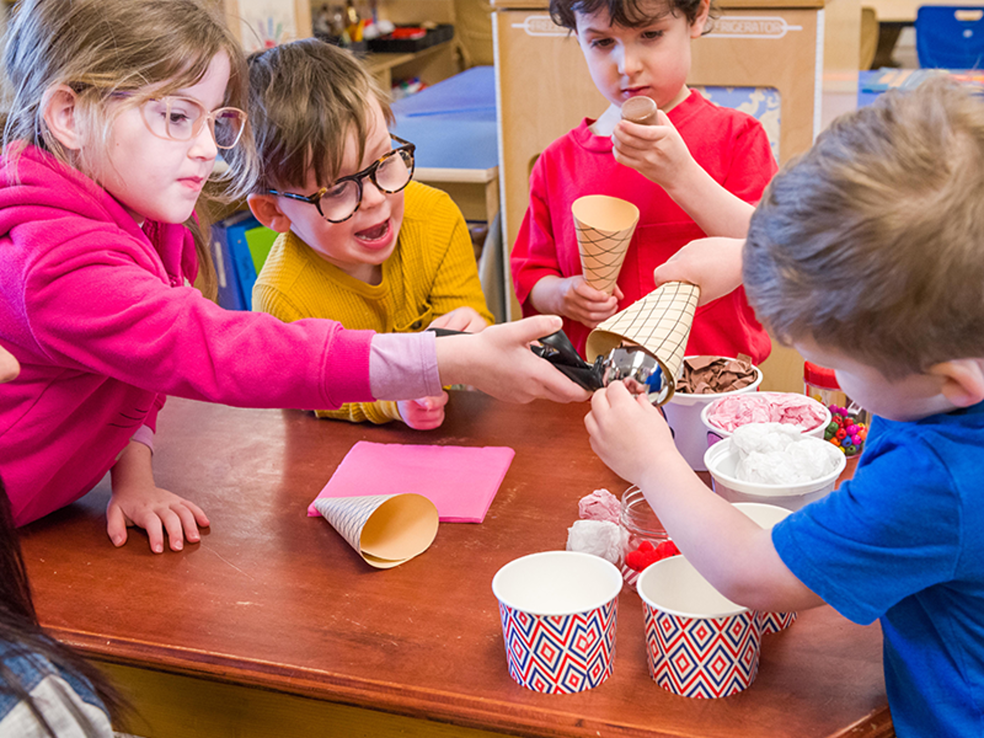enfants jouant avec un ensemble de crème glacée dans le coin de jeu de rôle