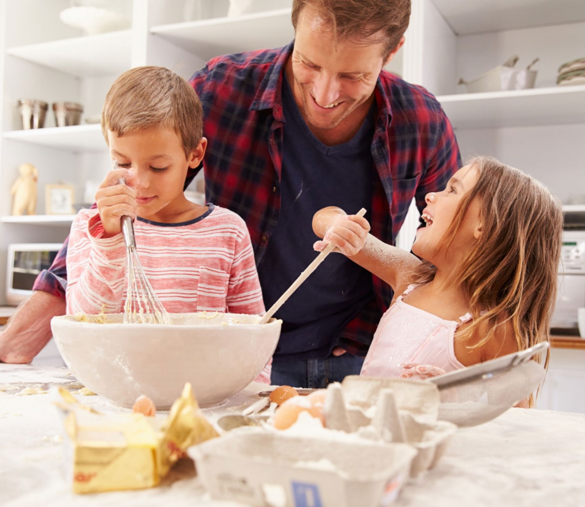 Père et deux enfants cuisinent ensemble