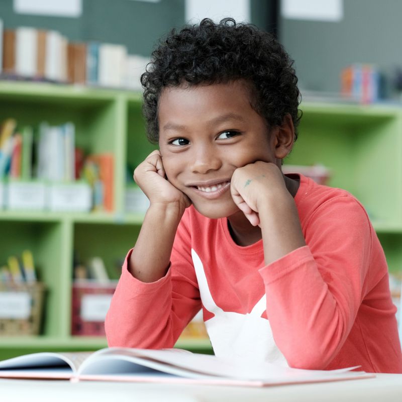 Jeune Garçons sourit à la camera en classe